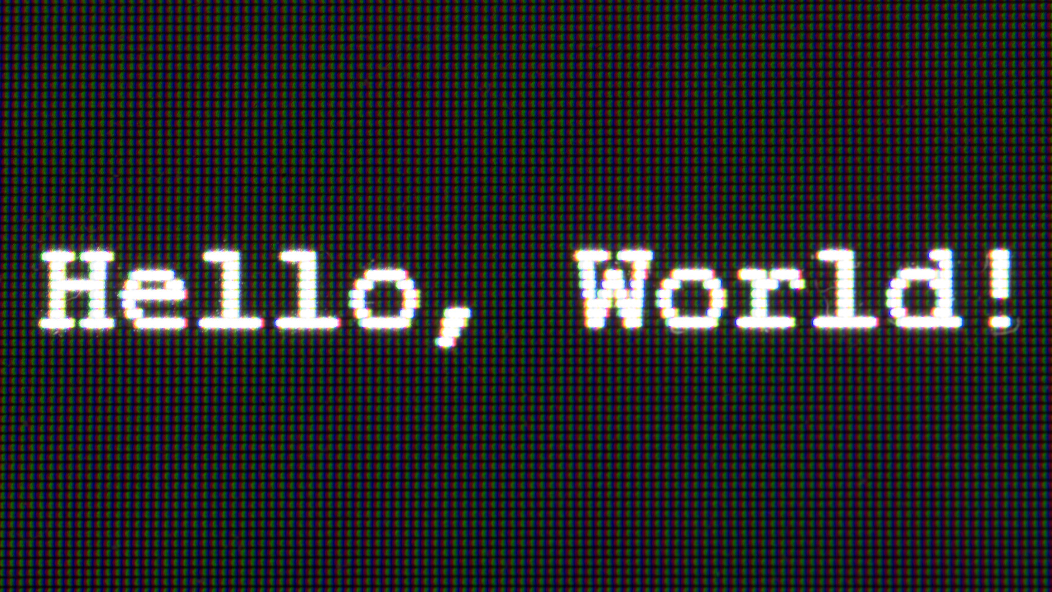 close up of a computer screen showing pixels that reads hello world